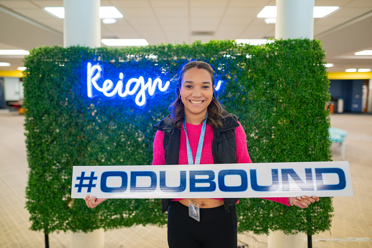 Female student holding a #ODUBOUND sign