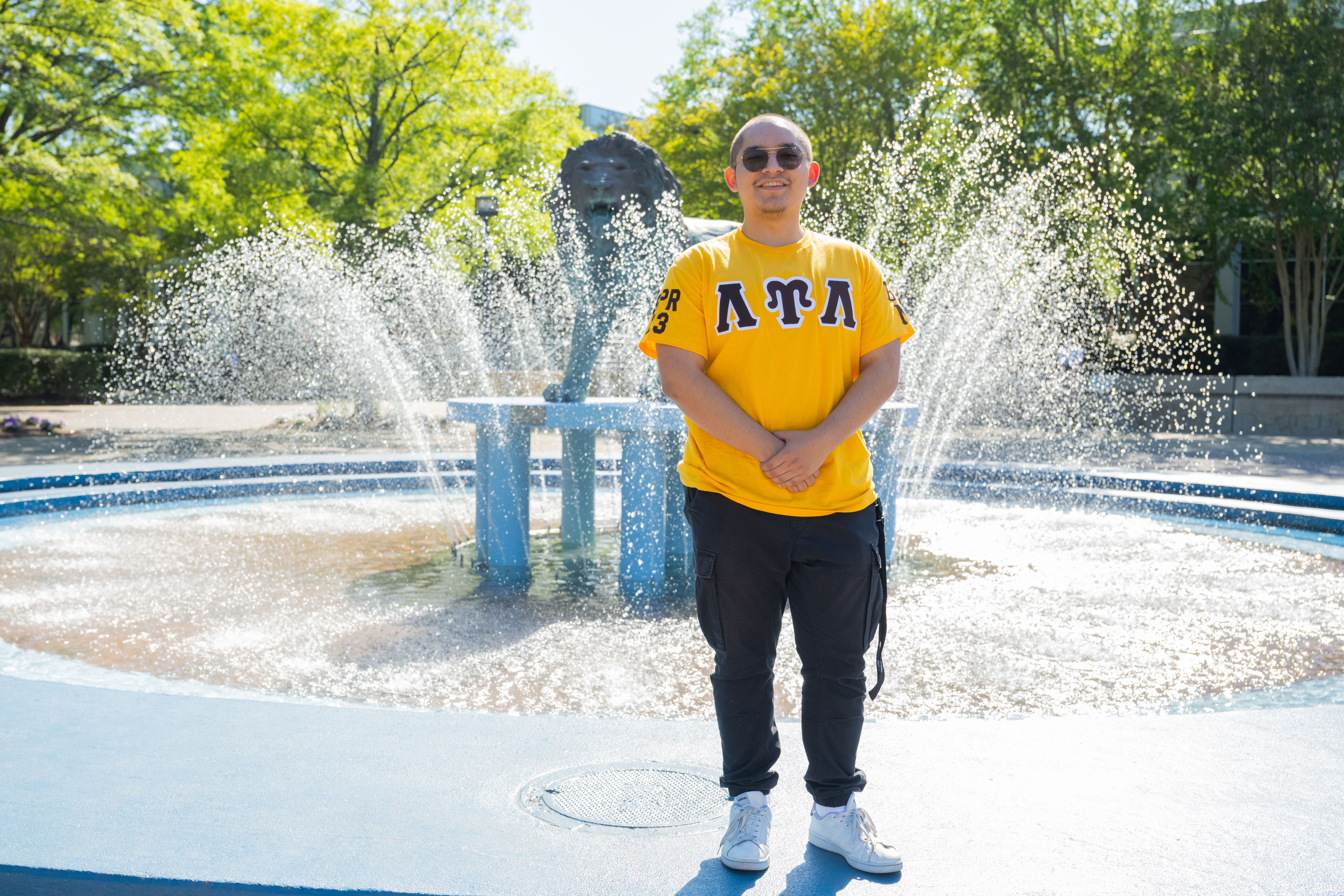 Fraternity member stands in front of fountain