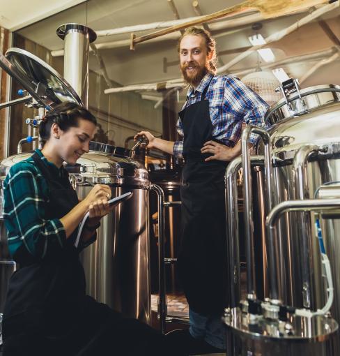 Man and woman brewing beer with giant mashtons