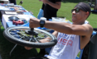 Jesse Moody, president of Society of Physics Students, demonstrates motion using a bicycle wheel. Photo David B. Hollingsworth/ODU