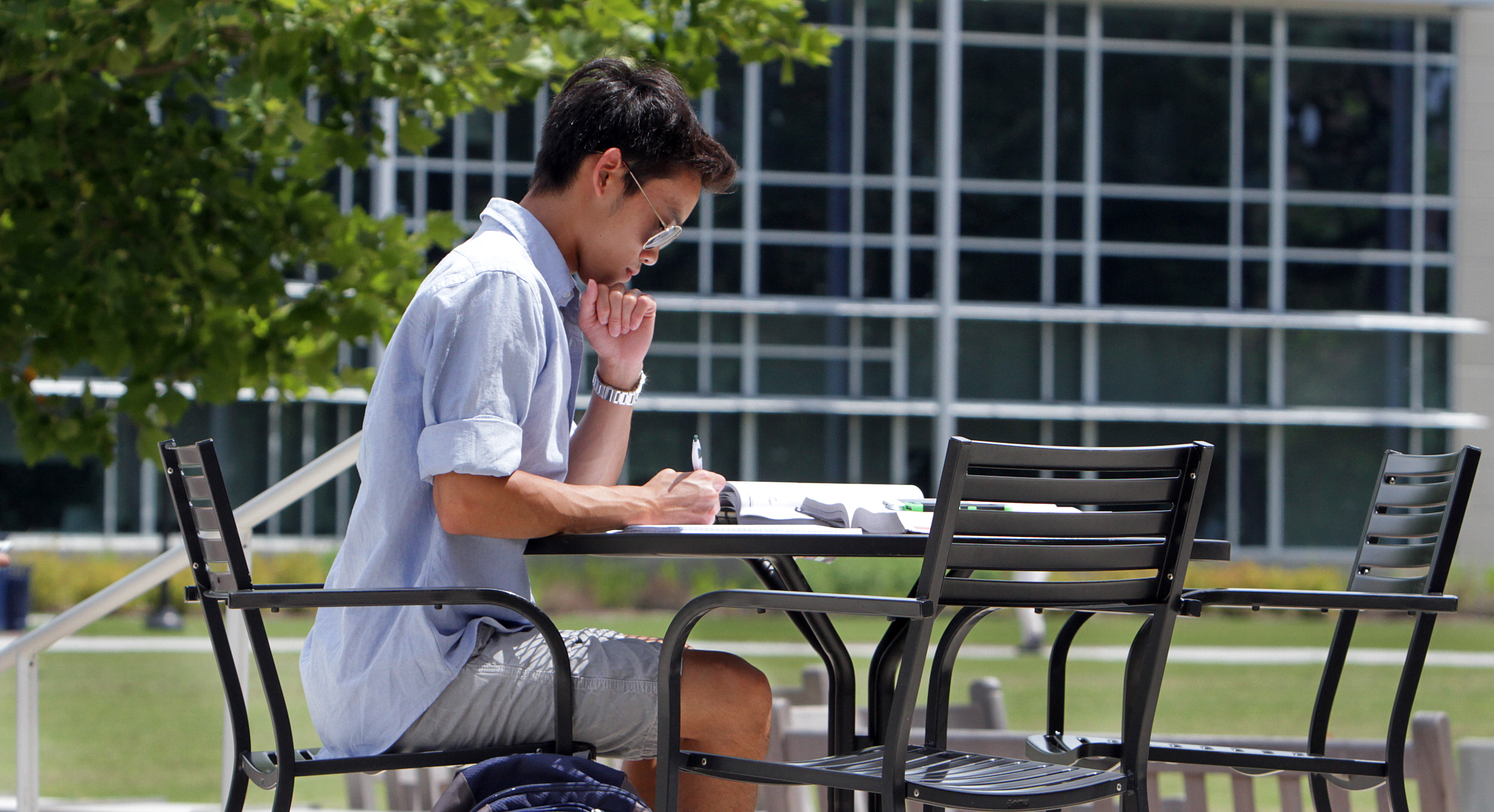  student studying in front of Perry Library