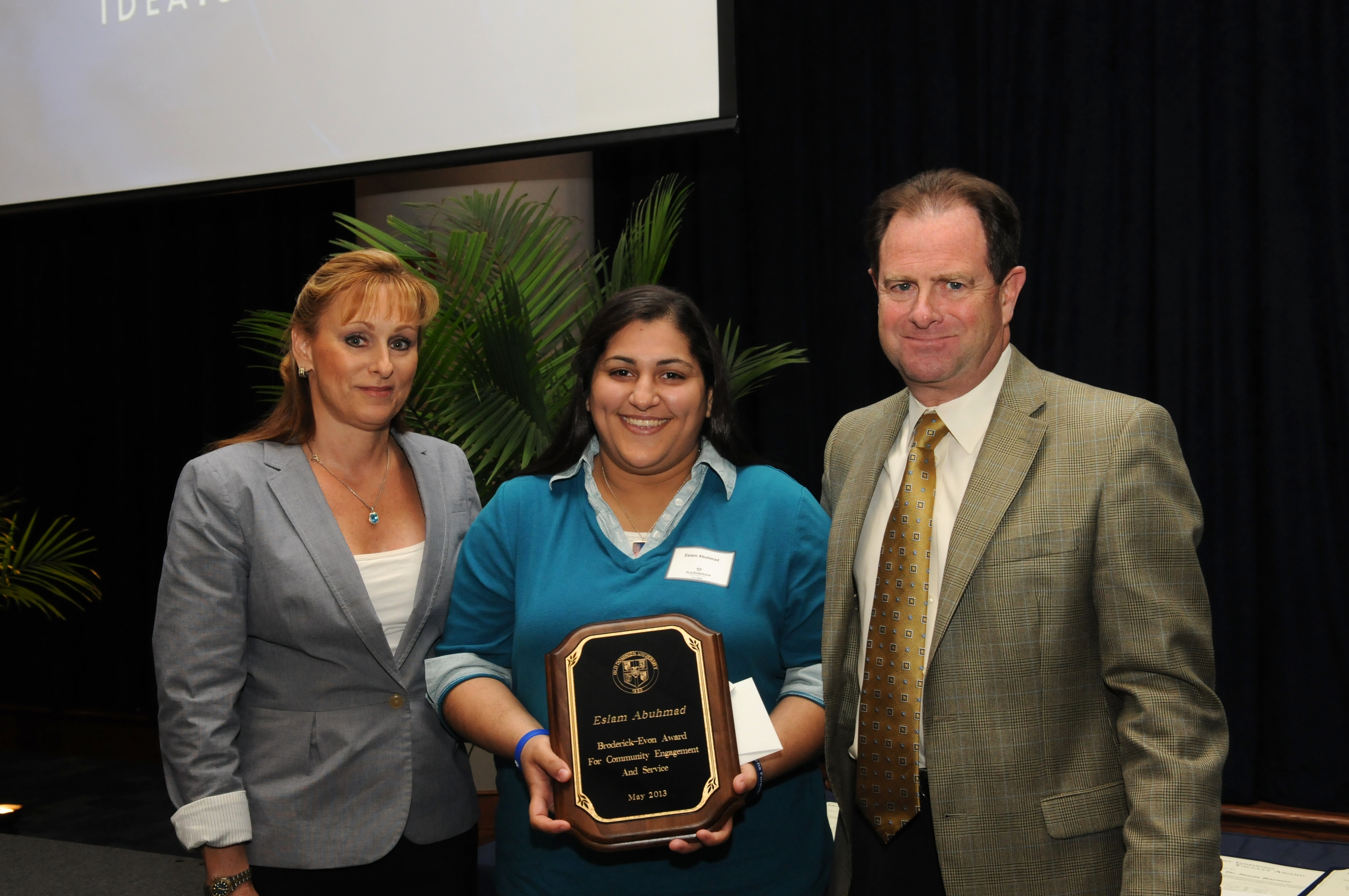 Photo of Broderick Evon award winner Eslam Abuhmad (center) with President Broderick and his wife Kate.