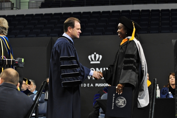 President Broderick congratulates a graduate at the spring commencement exercises.