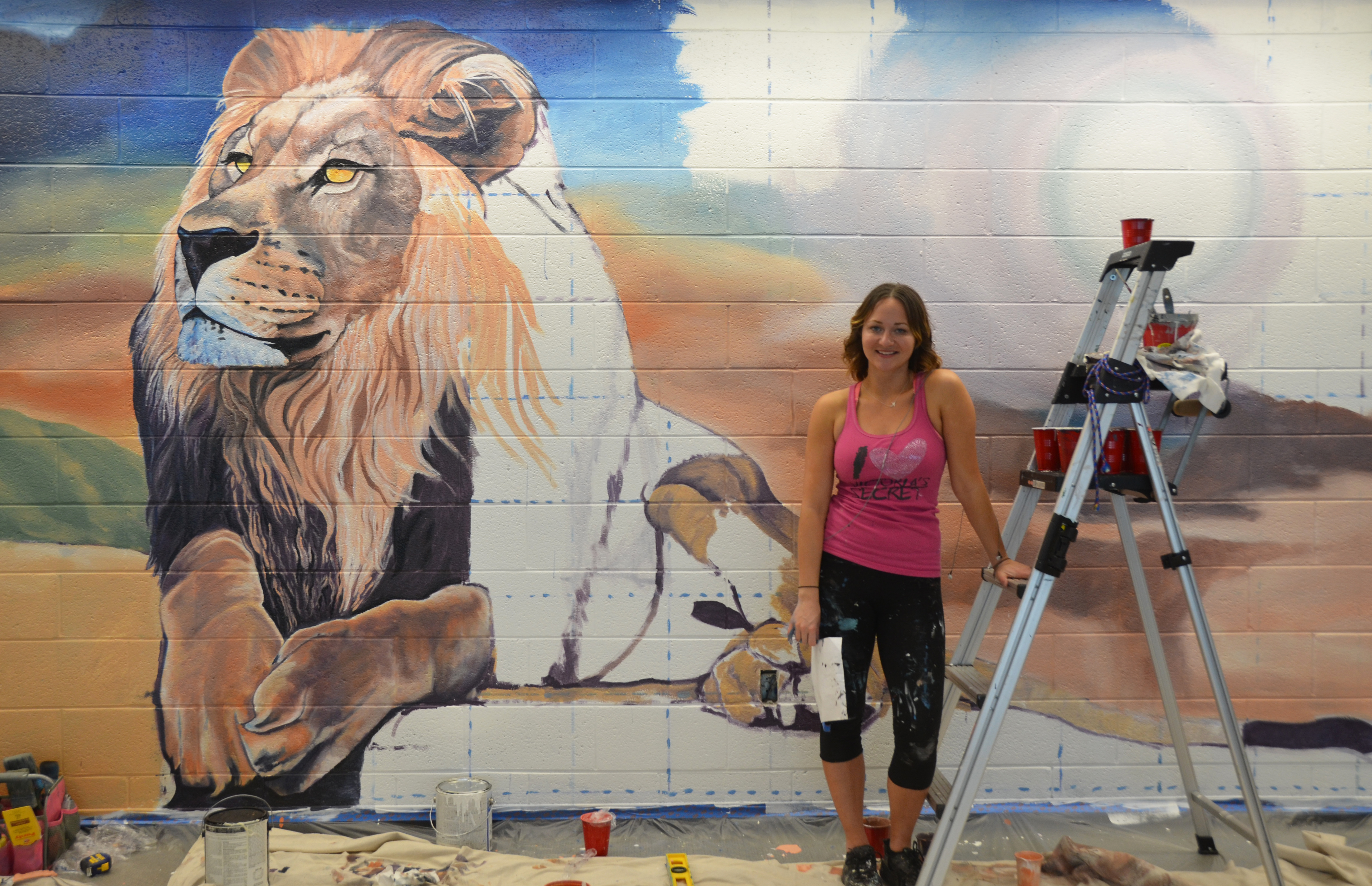 Photo of Jaimie Phillips and lion mural at Perry Library