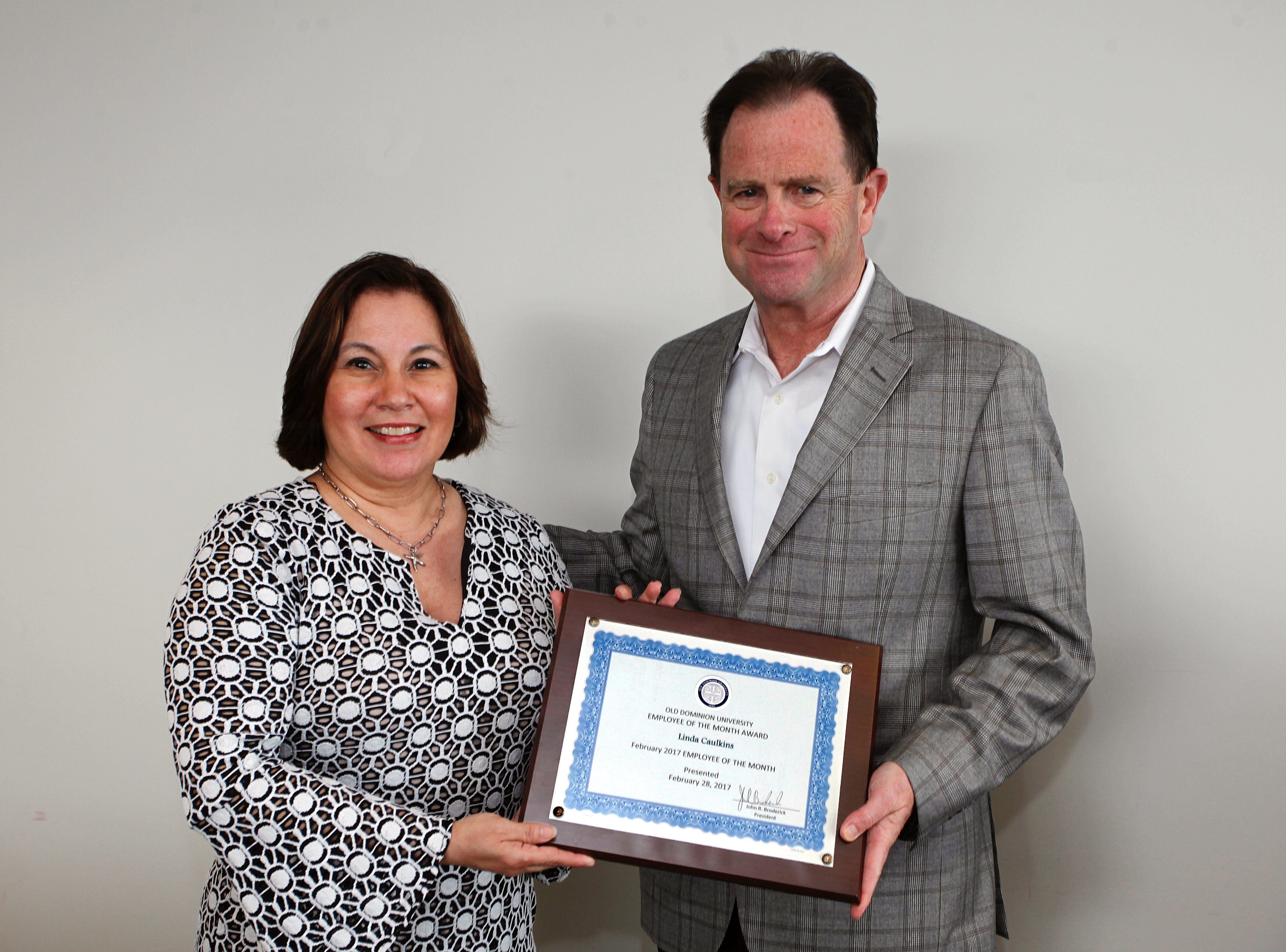 Linda Caulkins receives the Employee of the Month award from Old Dominion President John R. Broderick