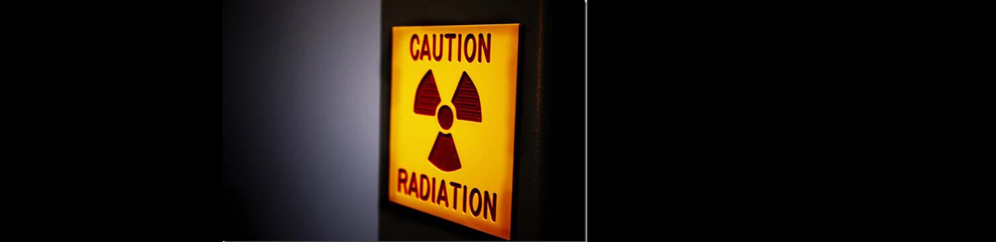 Illuminated sign reads "Caution Radiation"