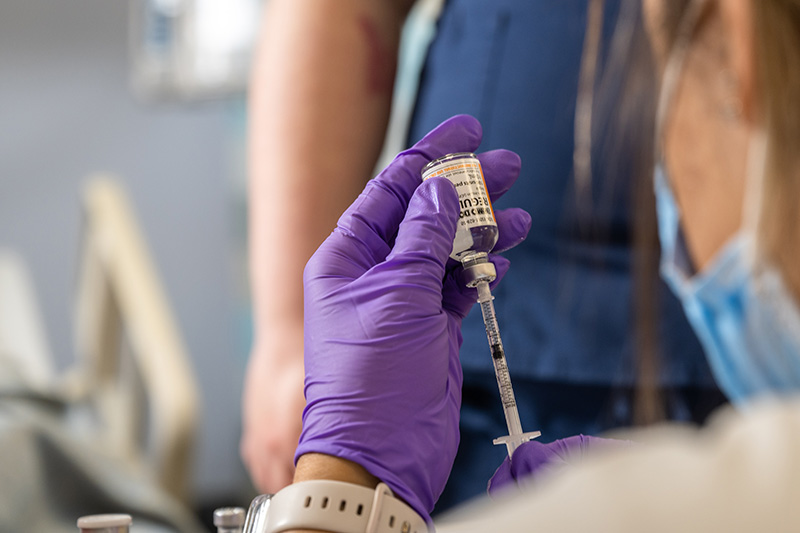 Nurse draws medication from a vial