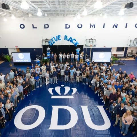 A group of people standing in a gym.