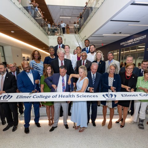 group of people cutting a grand opening ribbon