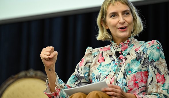 A woman makes a fist while talking.