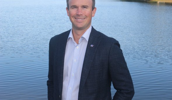 A man stands near a lake