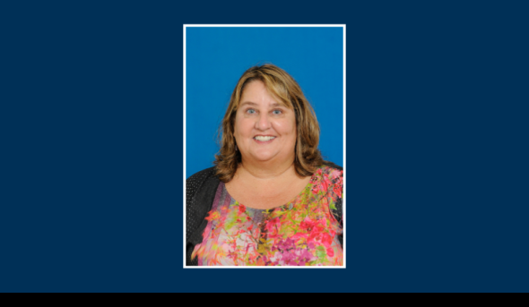 Headshot of an individual on a blue background.