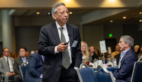 A man speaks to a crowded audience.