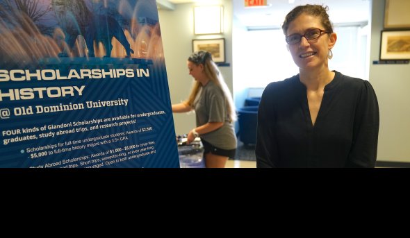 A woman stands in front of a poster board.