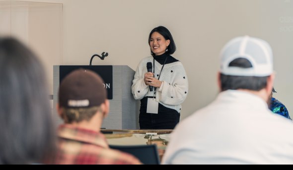 A woman speaks to a group of people.