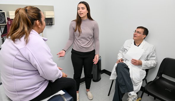 A woman talks to a patient in a doctor's office.