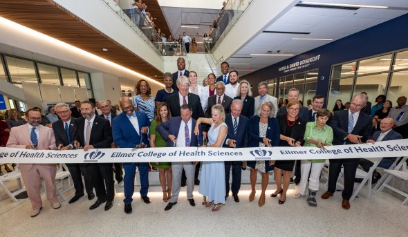 group of people cutting a grand opening ribbon