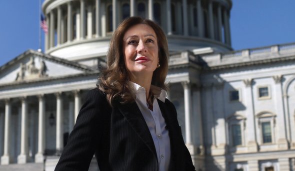 a woman stands in front of a building 