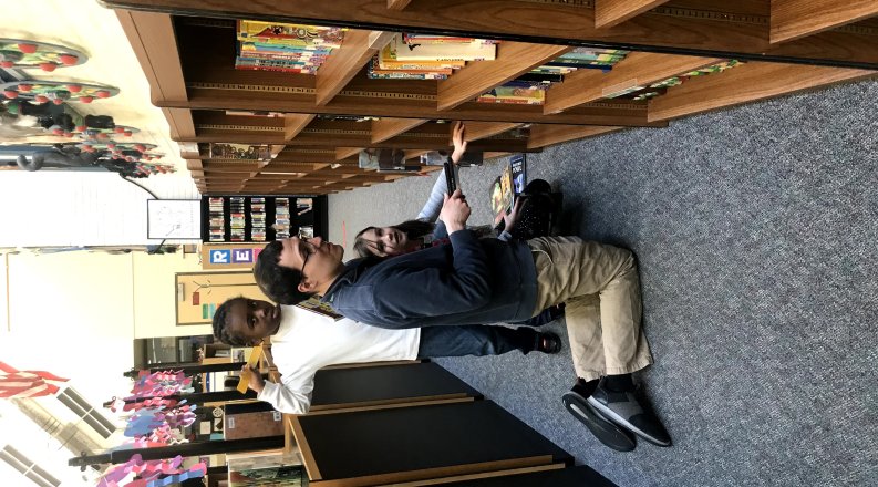 Greg D'Addario in elementary school library with students