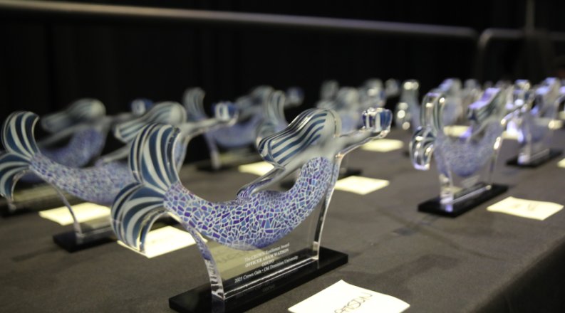 Glass mermaid-shaped awards on a table