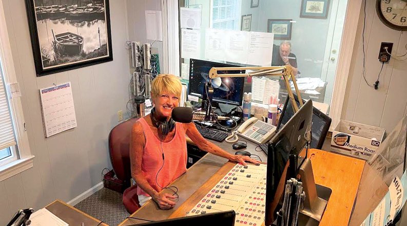 a woman sits in a radio studio 