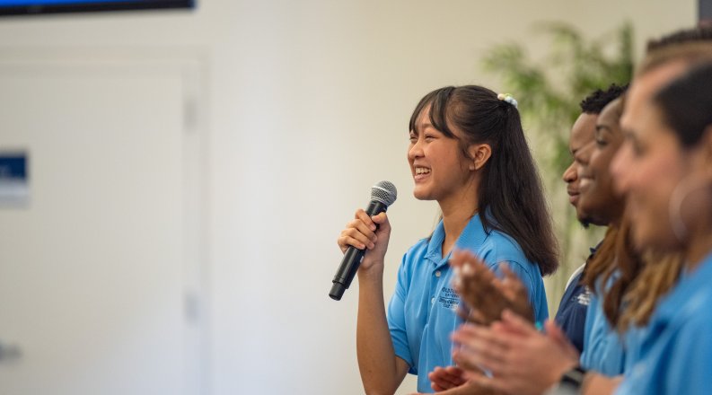 A woman speaks into a microphone.