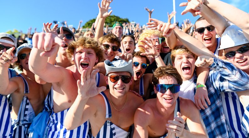 A group of people in the stands at a football game.