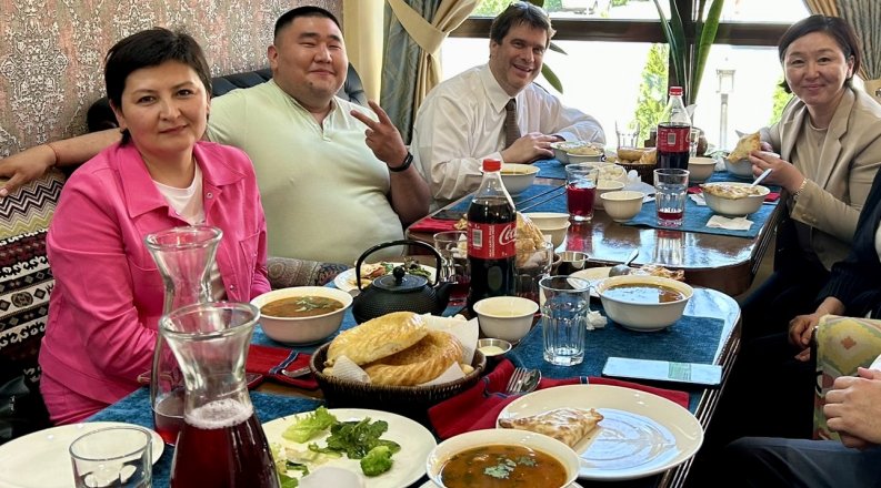ODU professor Jim Blando, Ph.D., sits with other people at a table eating lunch 