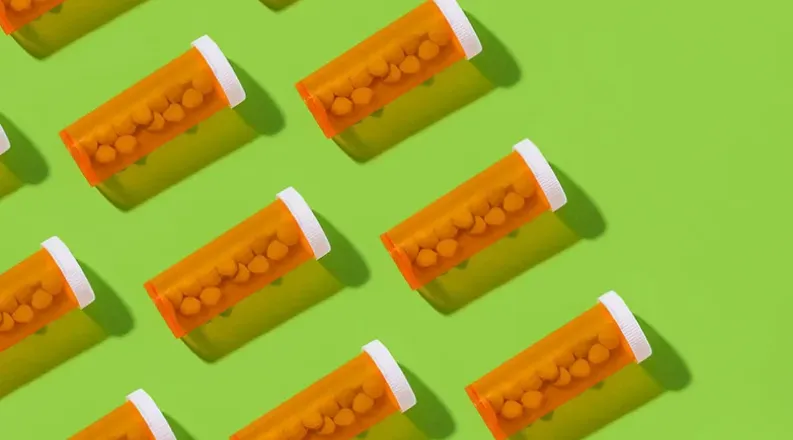 Several bottles of prescription medicine are laying flat aga