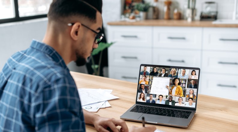 A person in front of a laptop engaging with a group of people online