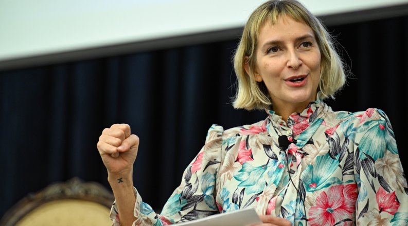 A woman makes a fist while talking.