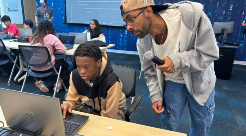 Two people looking at a laptop 