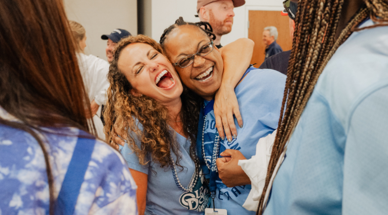 Two women hugging and laughing