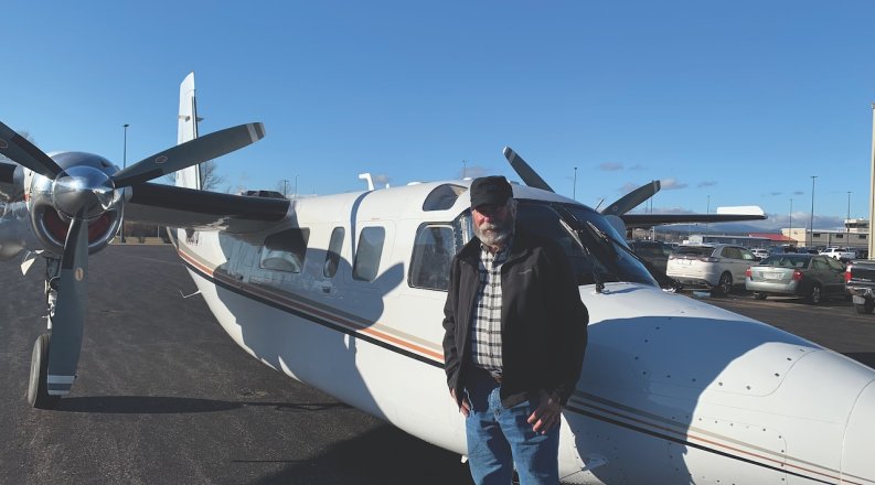 a man stands next to a plane 