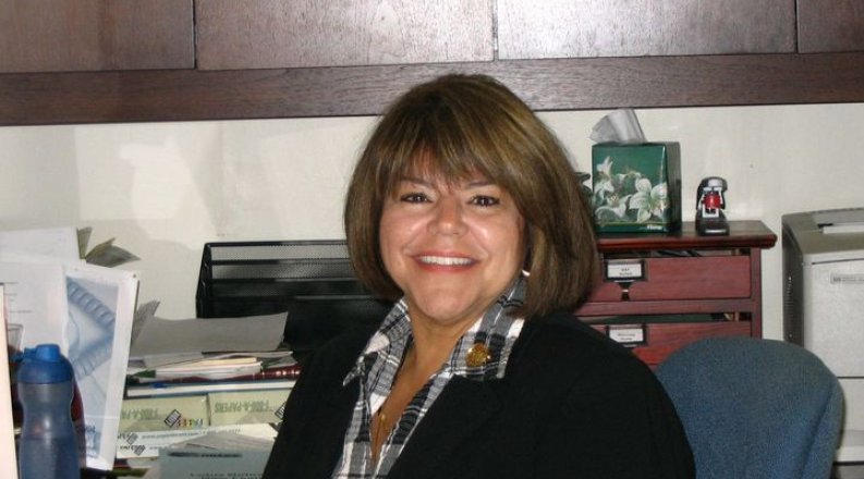 a woman sits at her desk