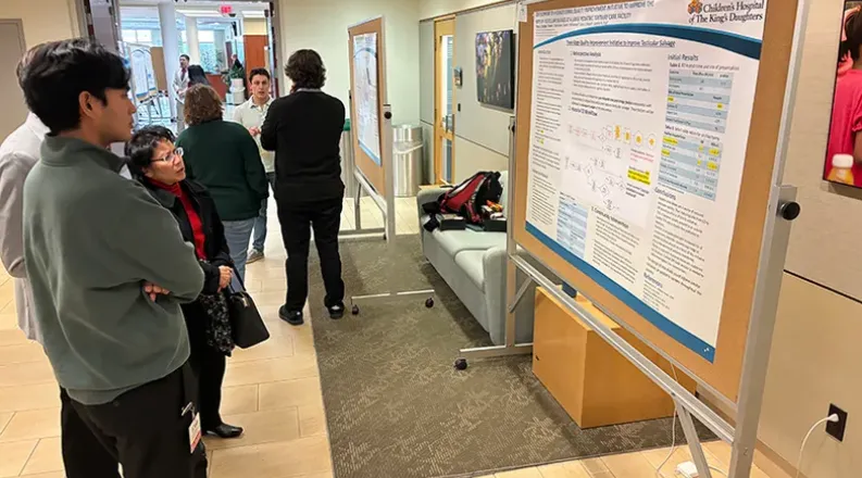 students sharing their research posters in a hallway.