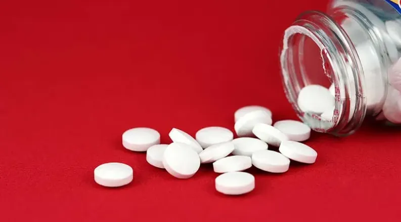 small white pills and a pill bottle