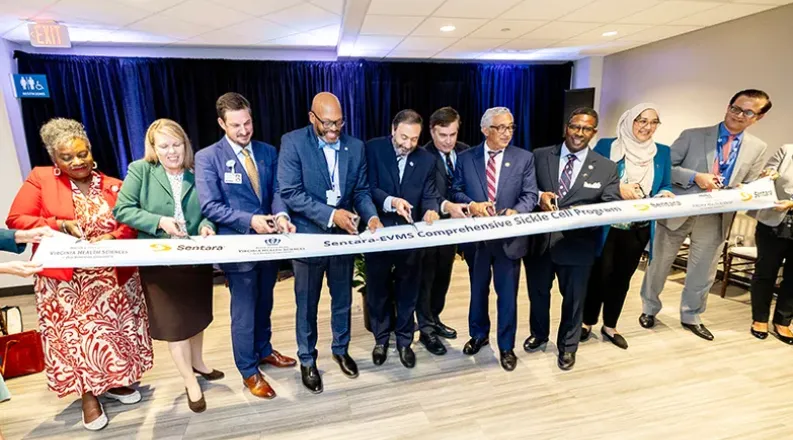 A line of various people each holding a pair of scissors cut