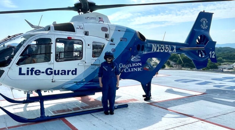 Woman standing in front of medical helicopter.