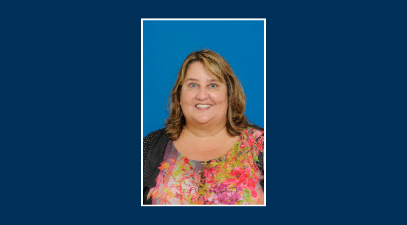 Headshot of an individual on a blue background.