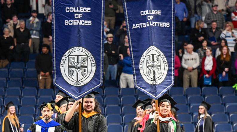 ODU students carrying college banners at commencement.