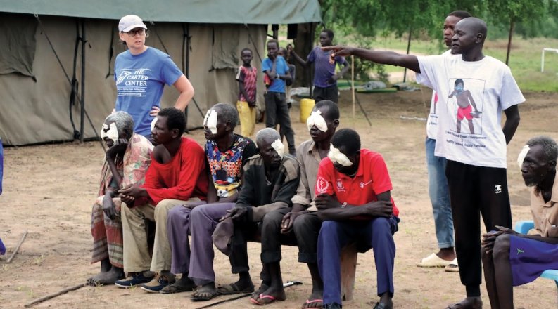 woman stands next to people sitting and one person pointing 