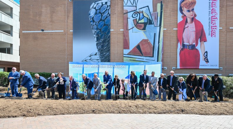 A group of people sticking shovels in the ground outside the Barry Art Museum.