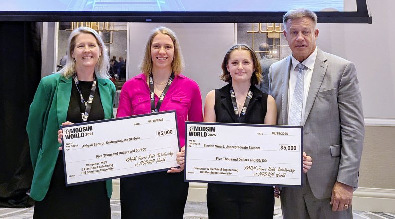 four people smiling, two holding big checks