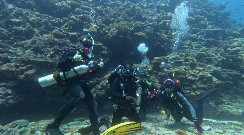 Dan Barshis poses for photo under water wearing scuba gear