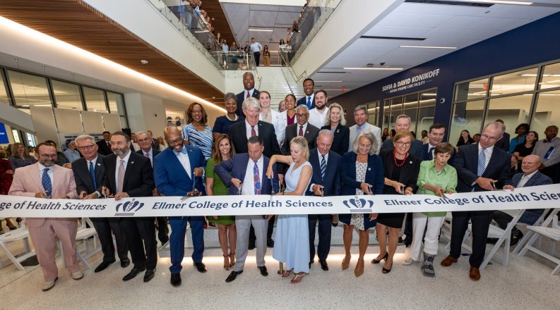 group of people cutting a grand opening ribbon