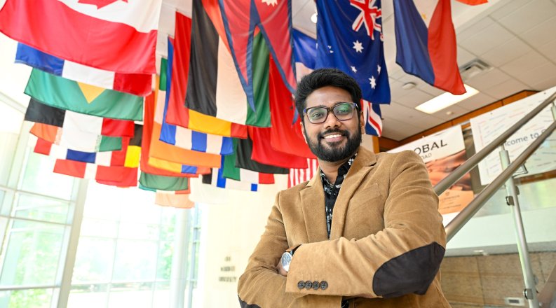 Man stands in front of flags