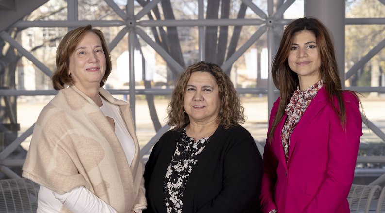 Three women pose for a photo. 