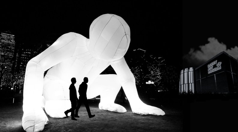 Art festival attendees walk past large ballon shaped like human