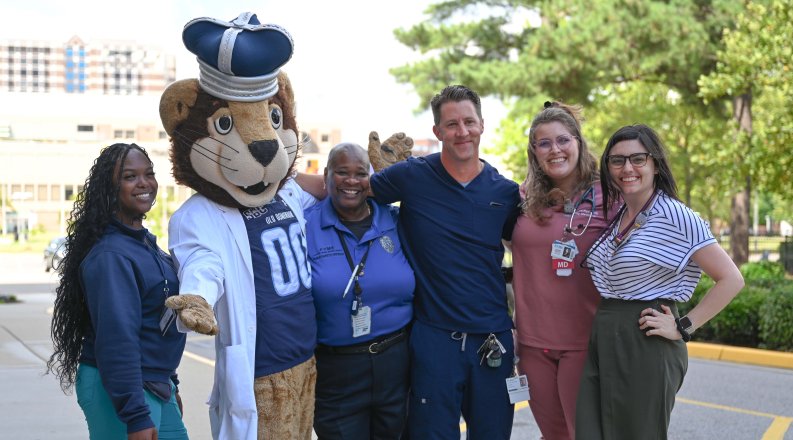 A group of people pose for a photo with Old Dominion University's mascot.